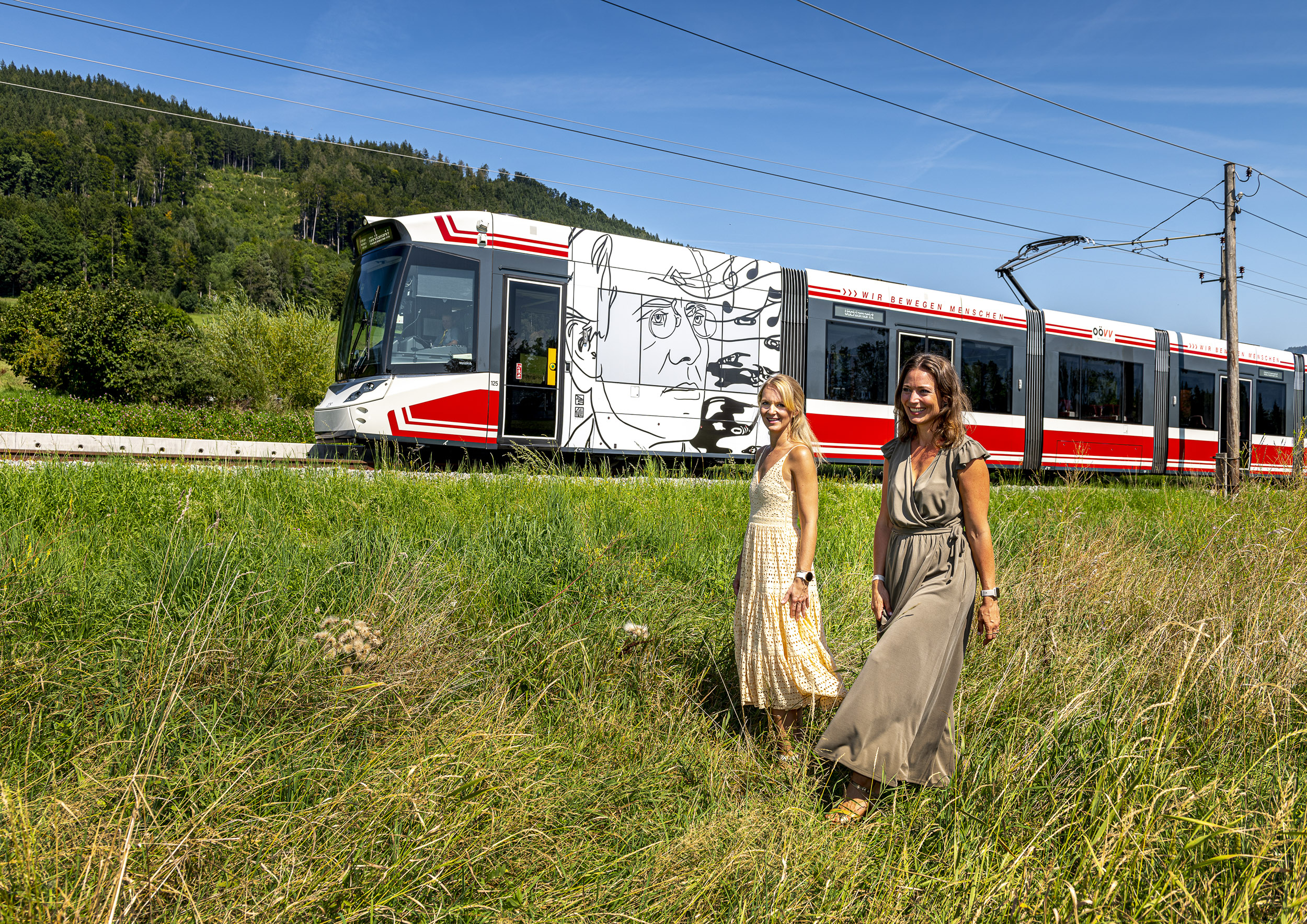 2 Frauen auf der Wiese vor der Künstlerbahn der Atterseebahn