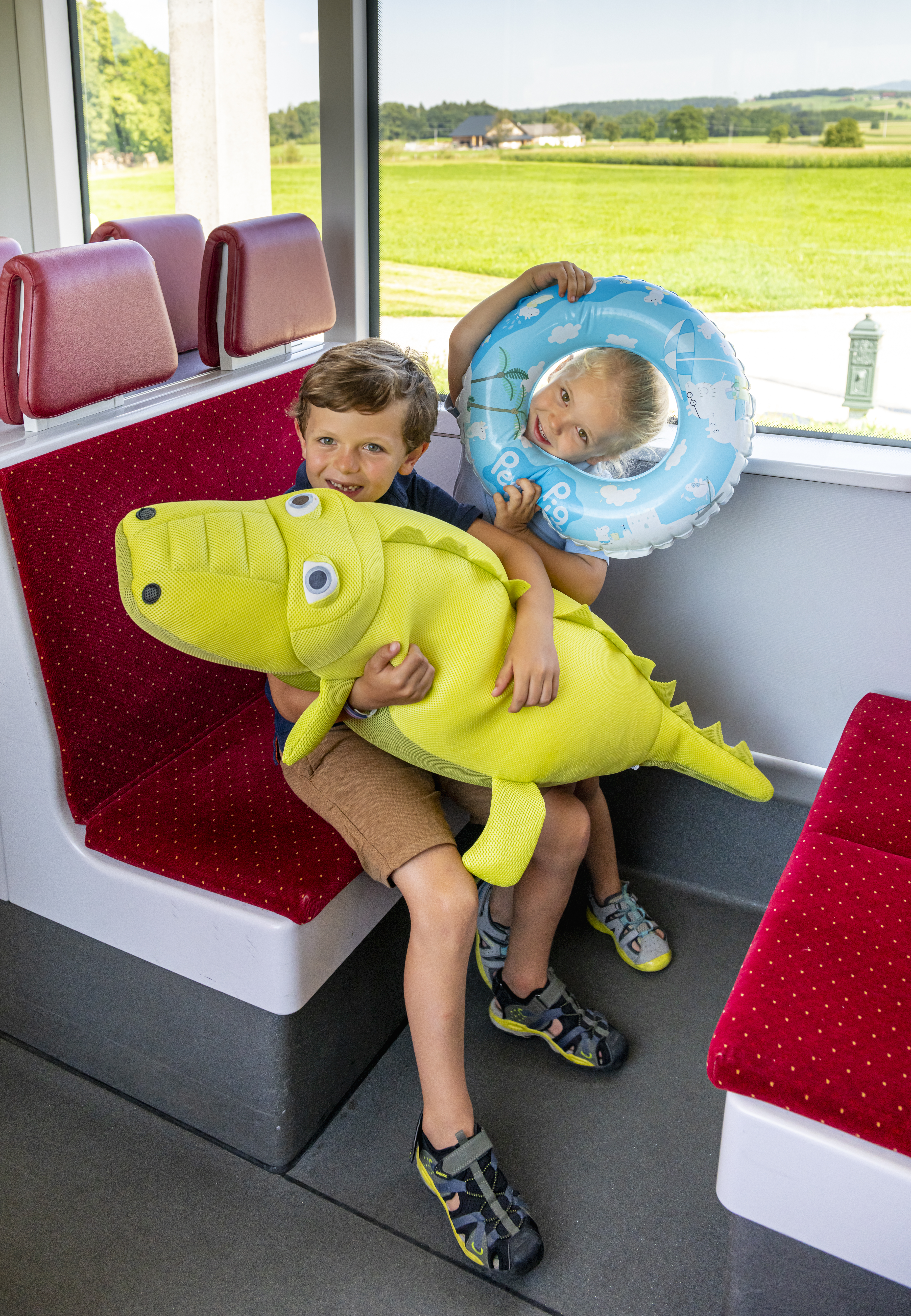 Kinder mit Badereifen und Krokodil in der Atterseebahn